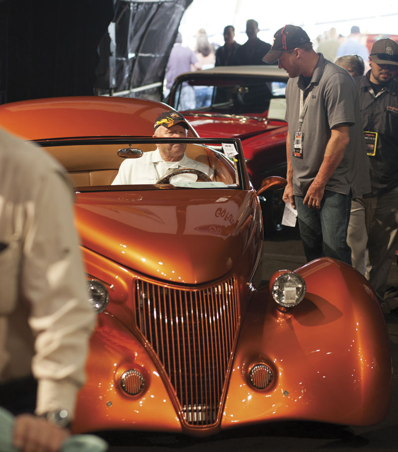A cinnamon pearl 1936 Ford custom roadster inches onto the auction block at Barrett- Jackson. The car fetched $92,400.