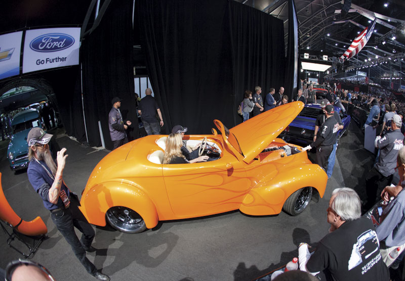 Prospective buyers look under the hood of a 1941 Willys Swoopster roadster. The car, which sold for $60,500, has an after-market 550-horsepower Corvette engine.