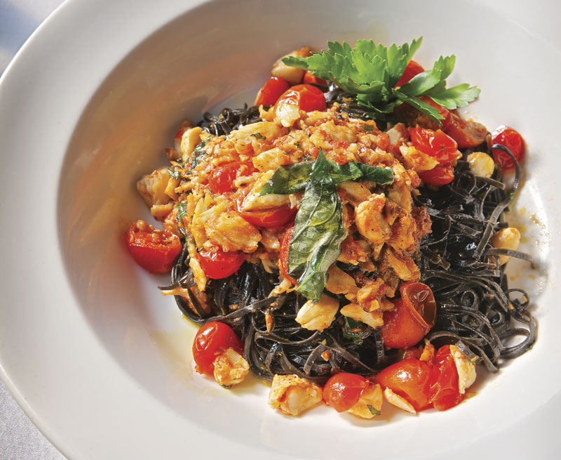 Squid-ink linguini with chunks of crab and cherry tomatoes