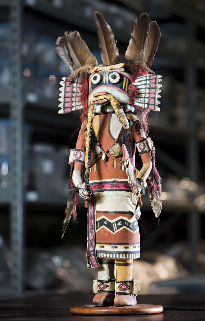 Wilson Tawaquaptewa (c. 1870s-1960), a Hopi carver and village chief of Oraibi on Third Mesa on the Hopi Reservation in Northern Arizona, created this carving (1930s-1940s) that combines numerous Katsinam and non-Katsinam figures. Materials include a three-dimensional stuffed snake, painted leather and several types of shells