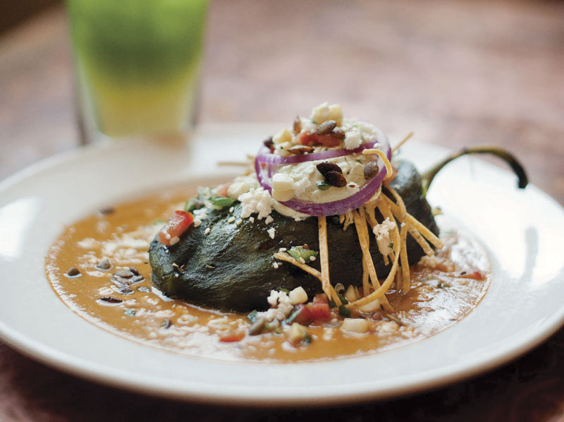 Elote Caf&eacute;'s Relleno de Pollo, a fire-roasted poblano chile stuffed with smoked chicken, vegetables and Tillamook cheddar, and topped with pipian rojo