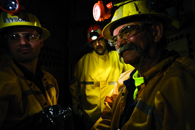 Left to right: Resolution Copper communications specialist Tyson Nansel, project engineer Rob Tobin and project manager Randy Seppala descend shaft No. 10 in a cage-like elevator. Photo by Mark Lipczynski