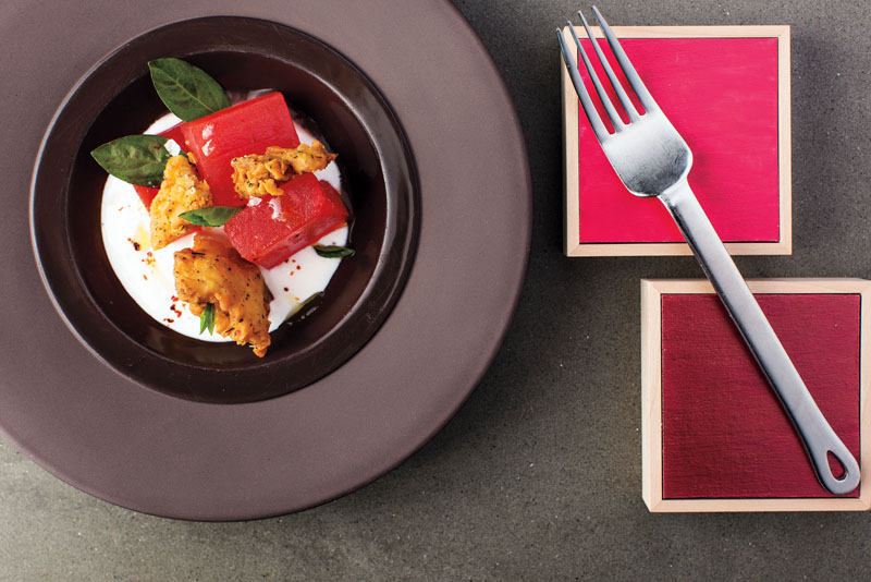 Watermelon with goat cheese, basil and crispy chicken skins. Photo by Blake Bonillas