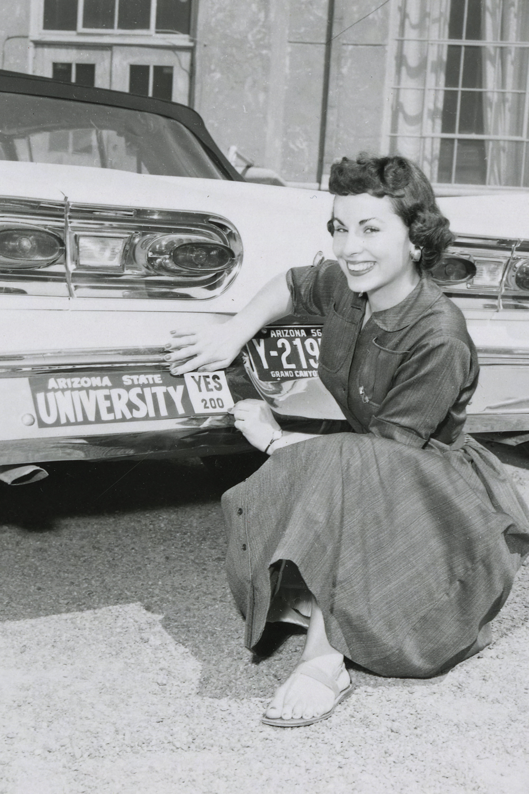 A supporter shows off her Prop. 200 bumper sticker, 1958