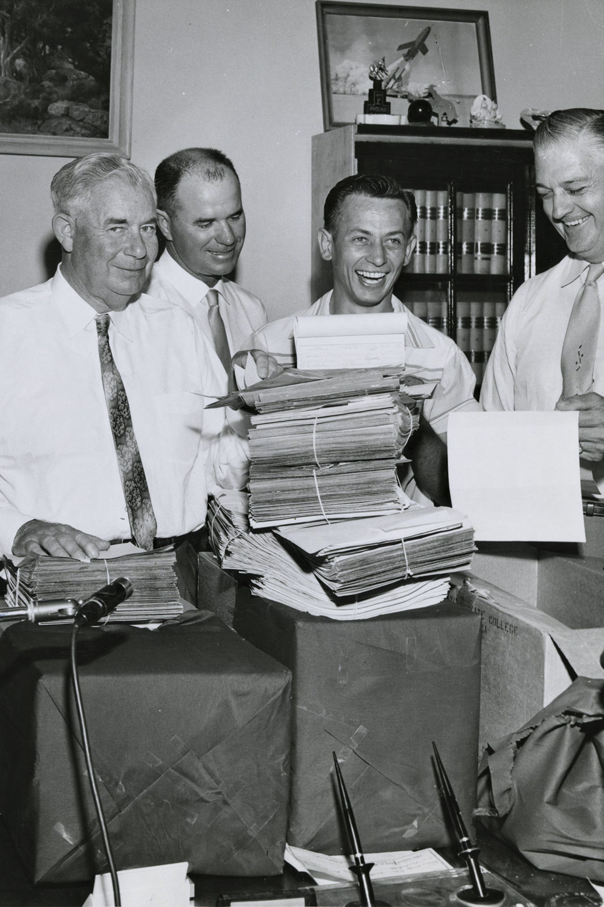 Gov. Ernest McFarland (far left), an unidentified man, James “Mr. ASU” Creasman and Arizona Secretary of State Wesley Bolin celebrate the proposition’s passage