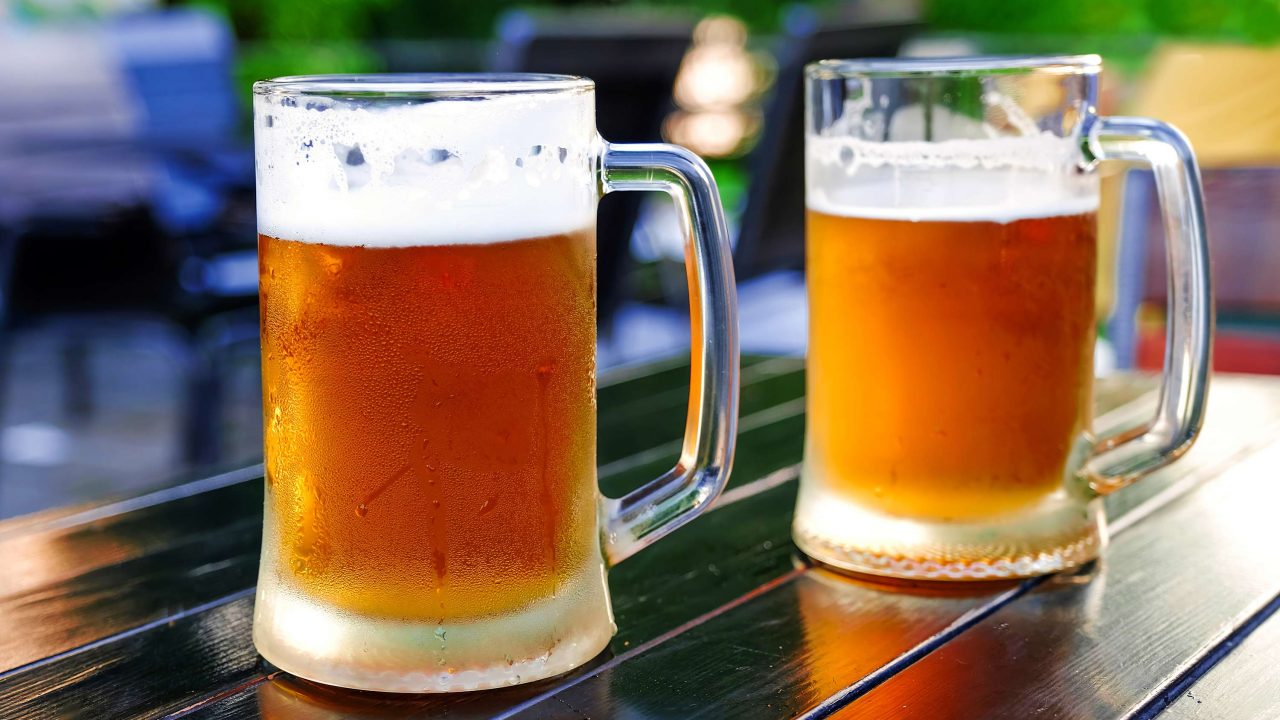 https://www.phoenixmag.com/wp-content/uploads/2021/04/Glasses-of-light-beer-with-barley-on-the-background-of-an-open-street-pub-1280x720.jpg