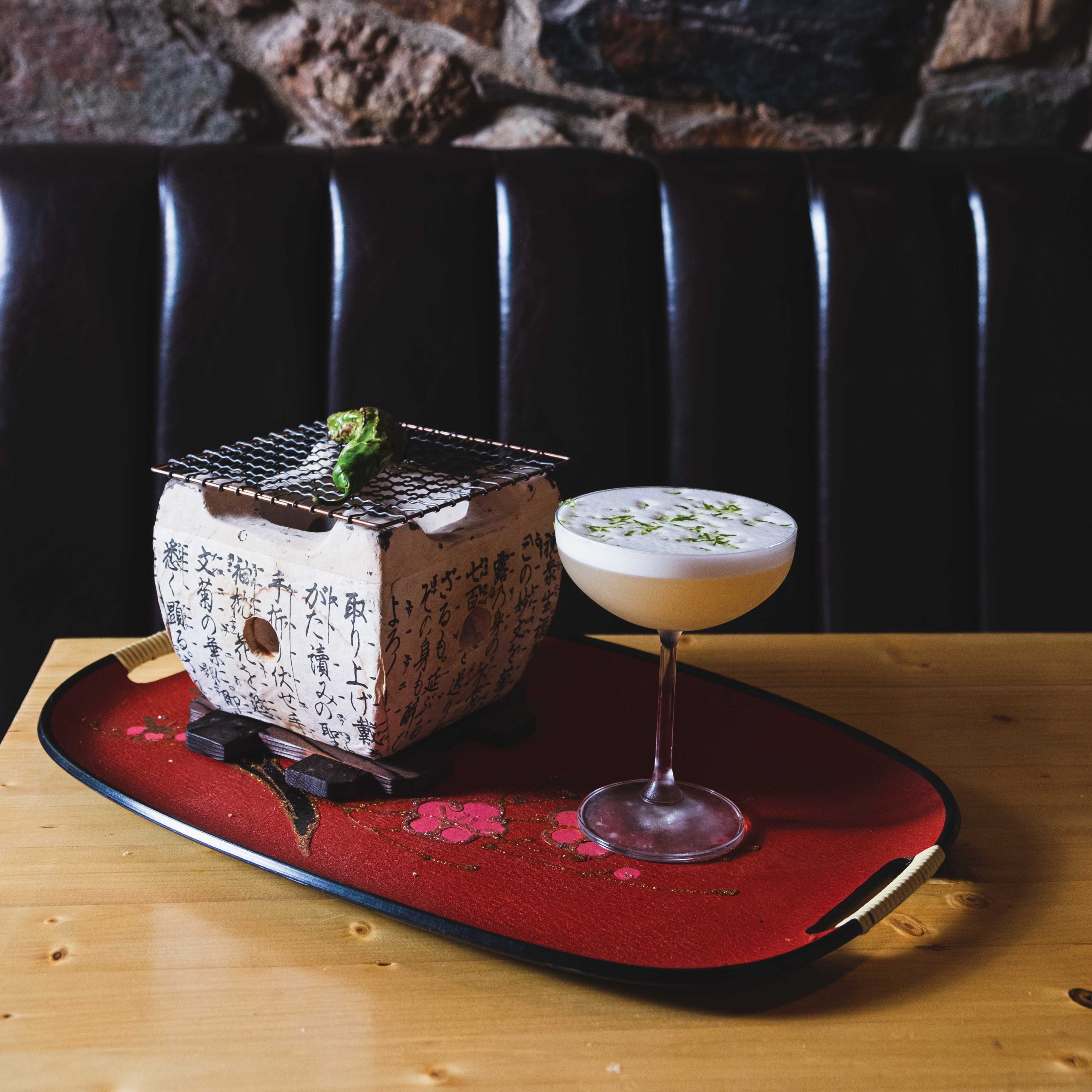 Iburi cocktail garnished with a hibachi-grilled shishito pepper