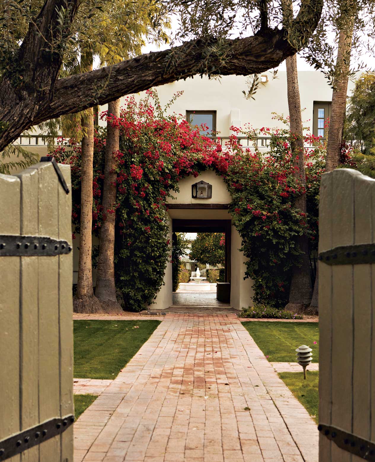 Brick-lined pathways meander through the common grounds of the Casa Blanca community. Through an archway, the central rose garden’s fountain can be can be seen in the distance. Brick-lined pathways meander through the common grounds of the Casa Blanca community. Through an archway, the central rose garden’s fountain can be can be seen in the distance.