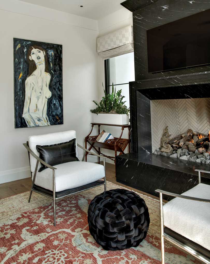 PHG0523Fennessy10 “I wanted to use timeless fabrics and finishes, especially in the master suite,” says the homeowner. Sumptuous textiles in earthy tones in the bedroom invite relaxation and restoration, while the black bed frame and black marble-clad fireplace anchor the space with a bit of drama. “I also love how the geometric moldings in the bathroom and bedroom give some texture and a classic feel to the house you don’t see very often.”