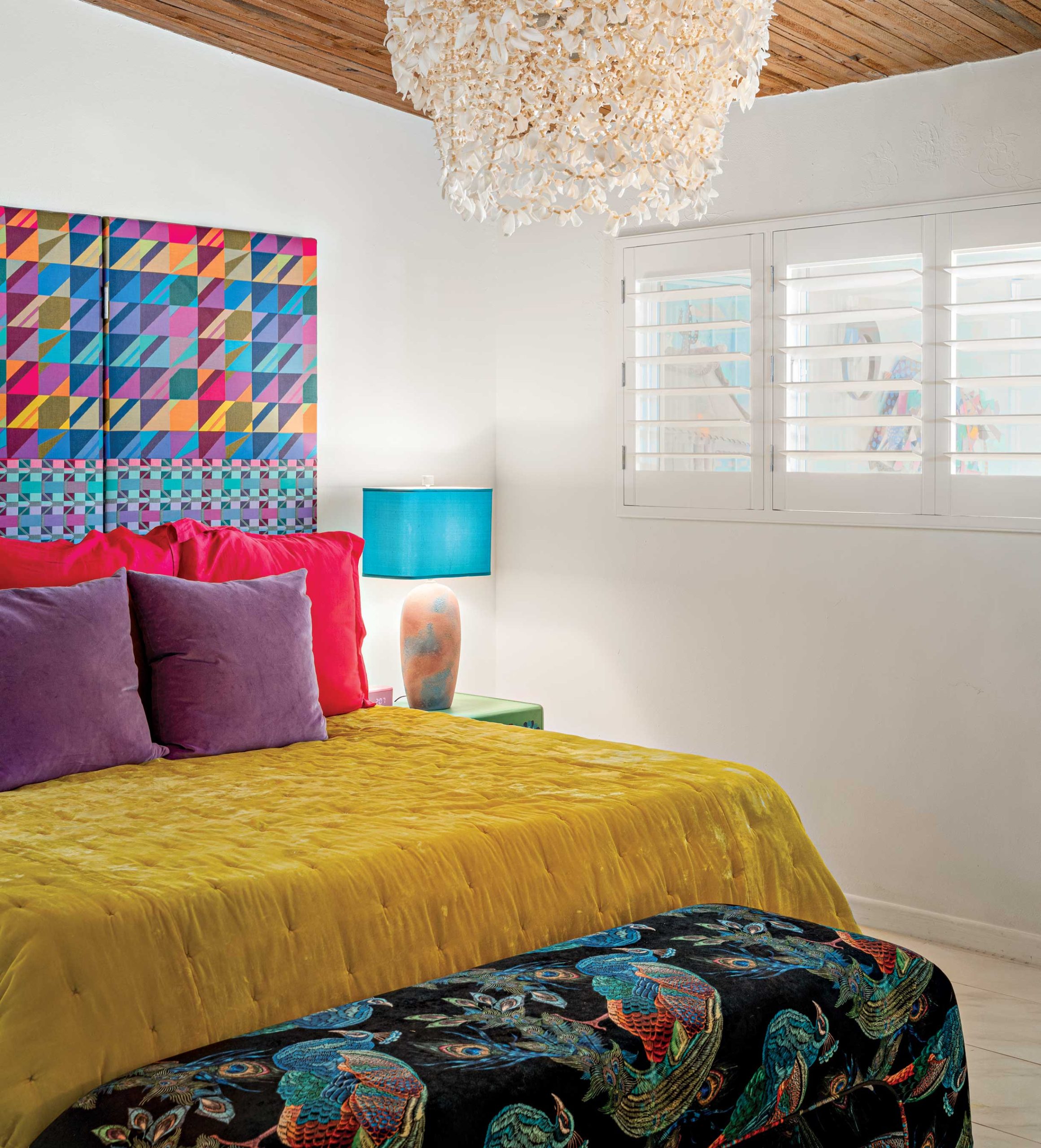 A guest bedroom marries nearly all the colors of the rainbow with fresh white walls and a seashell chandelier. A guest bedroom marries nearly all the colors of the rainbow with fresh white walls and a seashell chandelier.