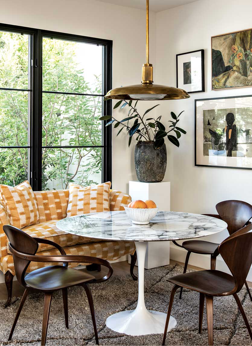 A classic Saarinen table and a reupholstered vintage settee partner up in the breakfast nook. A classic Saarinen table and a reupholstered vintage settee partner up in the breakfast nook.