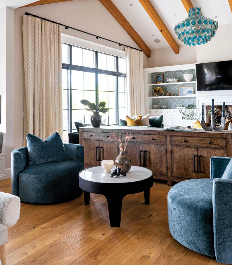 Between the great room and kitchen, interior designer Emily Yeates suggested deep aquamarine armchairs to create an inviting lounge area. Between the great room and kitchen, interior designer Emily Yeates suggested deep aquamarine armchairs to create an inviting lounge area.